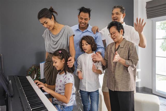 Asian Family Having a Singalong Around the Piano at Home