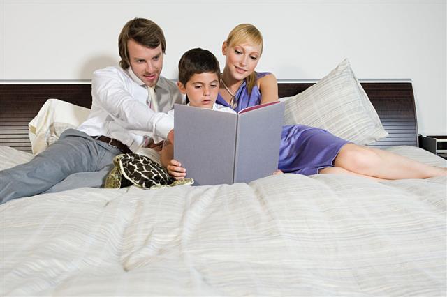 Родители читают книгу с сыном