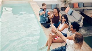 Group Of Friends Toasting At Pool Party