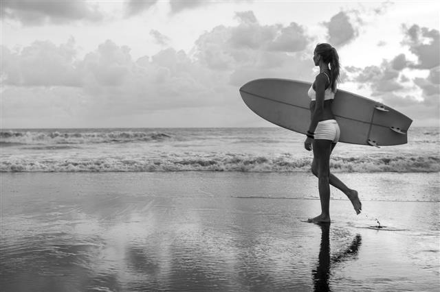 Woman With Surfboard On The Beach