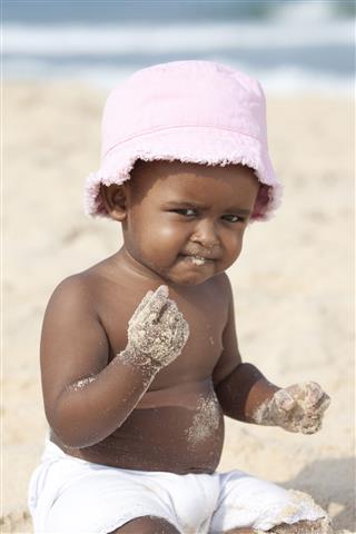 Baby Playing In Sand On The Beach