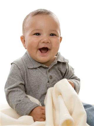 A Laughing Baby Holding A Towel