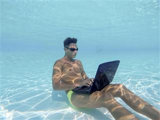 Young Man Using Computer Underwater