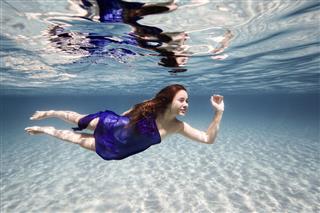 Beautiful Young Woman Swimming Underwater