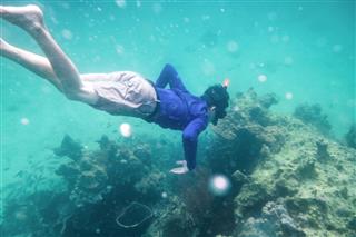 Man Diving In Emerald Andaman Sea On Coral