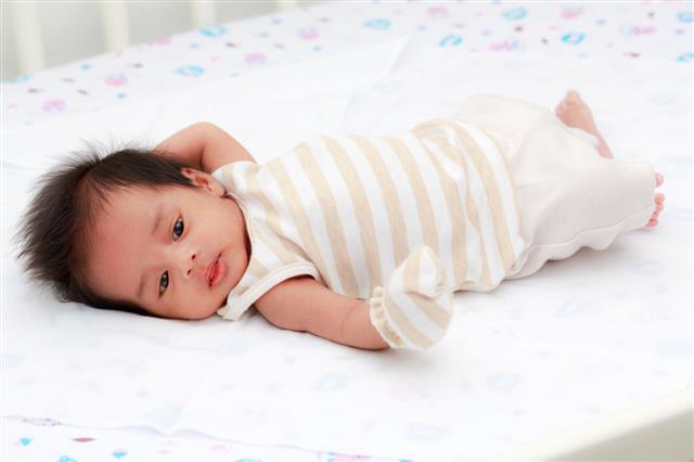 Happy Baby Lying On A Bed