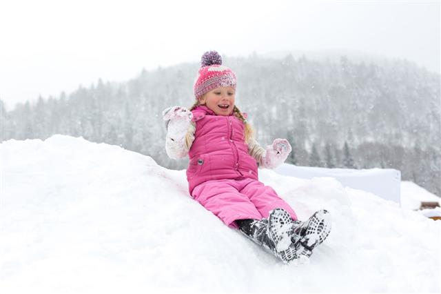 Little Girl Happily Playing In The Snow