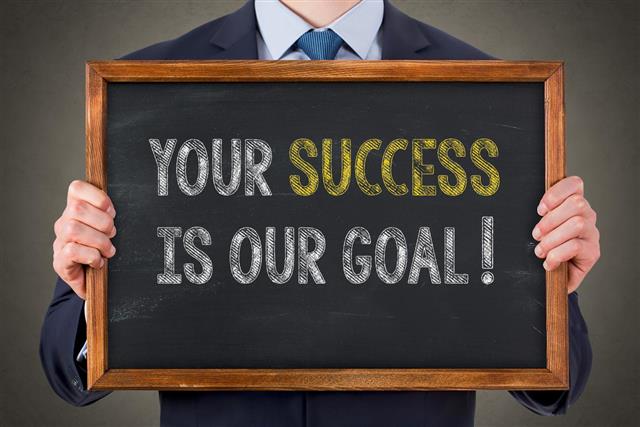 Human Writing Your Success Is Our Goal on Chalkboard