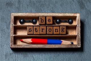 Be strong conceptual image. Vintage blocks with text in wooden