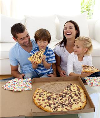 Parents And Children Eating Pizza