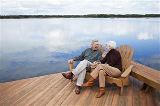 Senior Couple Sitting By Water