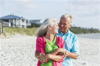 Affectionate Mature Couple Standing On Beach