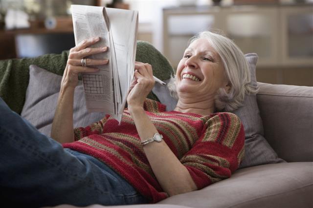 Elderly Woman Doing Newspaper Crossword Puzzle