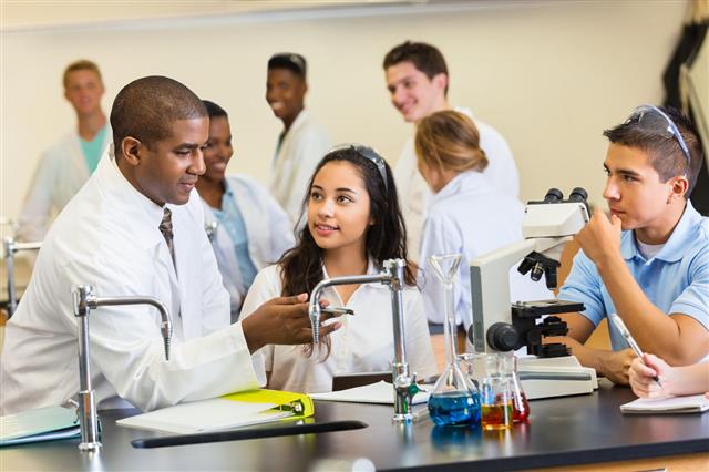 Teacher Talking With Students In Chemistry Lab