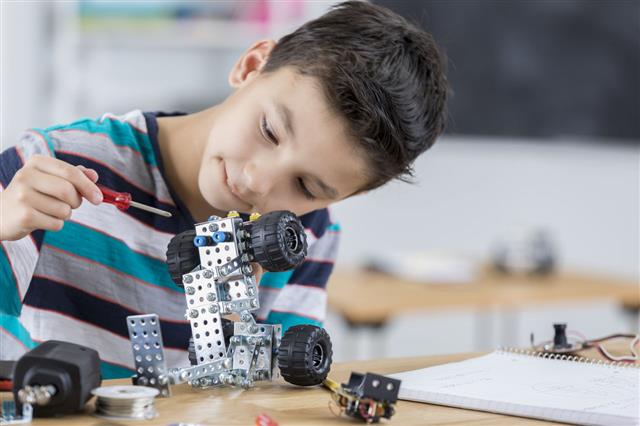 Boy Uses Tool While Building Robot
