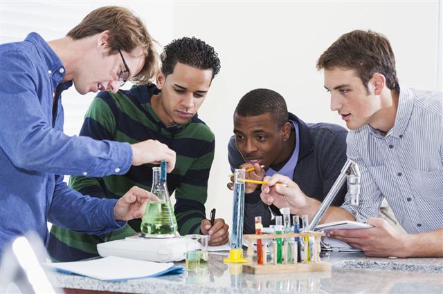 Group Of Male Chemistry Students Doing Experiment
