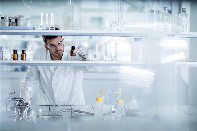 Chemist Choosing Bottle In Laboratory