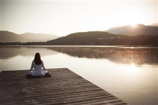 Woman meditating by lake
