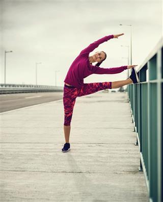 Athletic woman doing stretching exercise on the bridge
