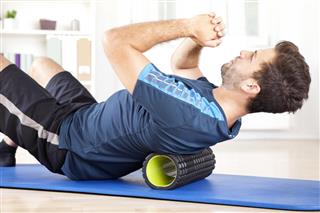 Man Lying on a Foam Roller While Doing an Exercise