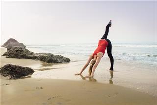 Woman doing yoga on the beach with reflection