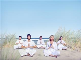 Group of People Doing Yoga on Beach