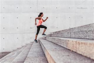 Latina sports woman running up outdoor stairway in berlin