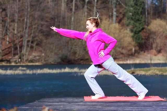 Teenage Girl In Tracksuit Doing Exercise