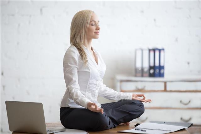 Businesswoman meditating in her office