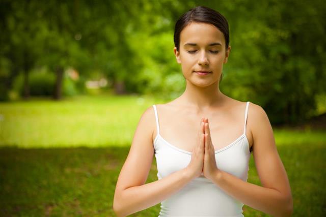 Young woman doing meditation outdoors