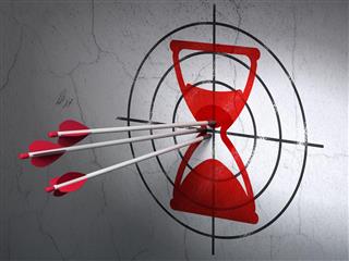 Time concept: arrows in Hourglass target on wall background