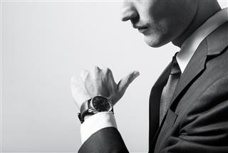 Close-up of businessman reading time on watch