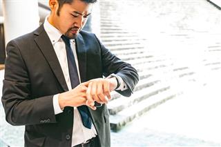 Japanese businessman checking his smart watch