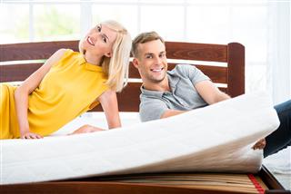 Young couple sitting on white bed