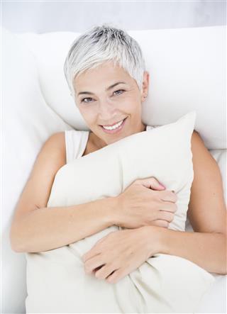 Mature woman in sofa with pillow