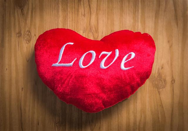 Love pillow on Wood Background