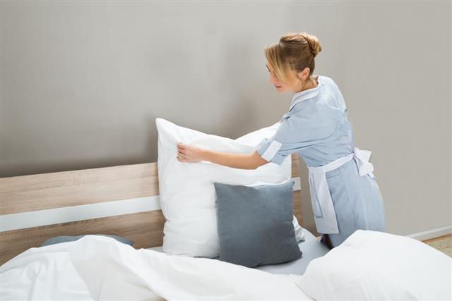 Housekeeping Worker Putting White Pillows