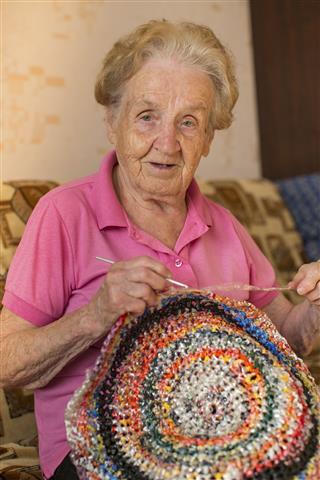 Woman Knits Crochet Rug