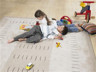 Children Lying On Rug At Home