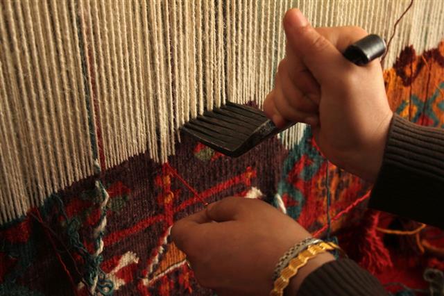 Woman Hand Weaving A Colorful Rug
