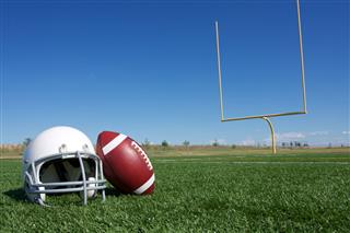 Football And Helmet On The Field