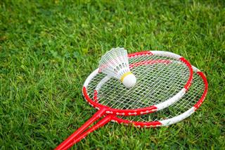 Badminton Rackets With Shuttlecock On Grass