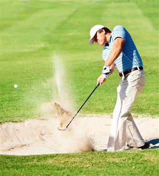 Mature Golfer Chipping The Ball From Sand Trap