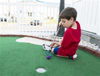 Boy Playing Miniature Golf