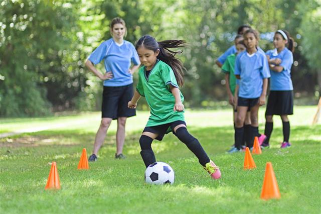 Elementary Age Soccer Athlete Kicks Ball
