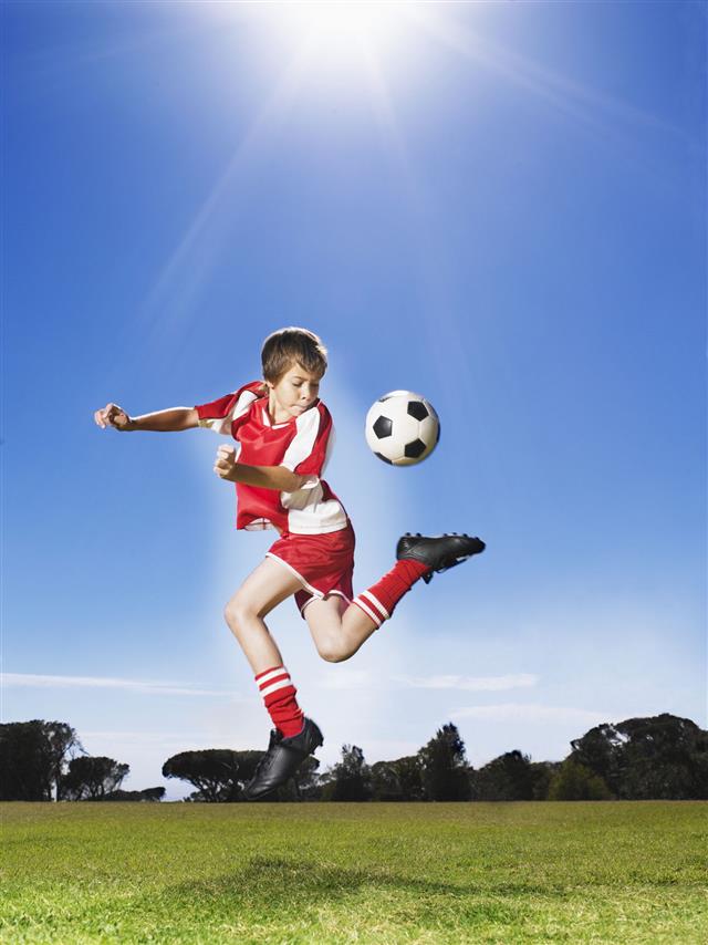 Young Boy Kicking Soccer Ball
