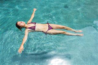 Woman Floating In The Pool