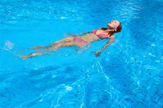 Girl Floating In Water Pool