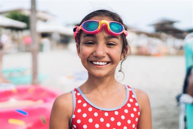 Little Girl With Swimming Googles Looking At Camera