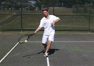 Male Tennis Player Takes A Swing
